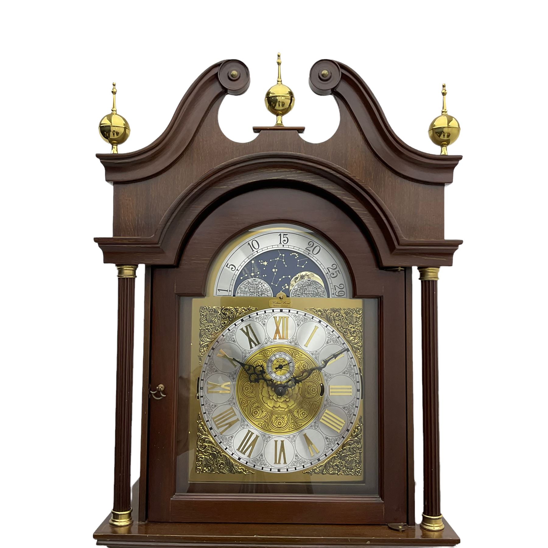 A  20th century longcase clock made to celebrate the millennium in the year 2000, this clock being No 2 of only 200 manufactured by  Richard Broad in Bodmin Cornwall, with a mahogany effect case and traditional swans neck pediment with three brass finials, break arch hood door on a trunk with recessed columns and full length glazed door, on a square plinth with inlay and a shaped base, brass dial with brass spandrels, silvered chapter ring, seconds dial and working moon phase to the arch, weight driven three train movement striking the quarters and hours on 12 gong rods, with a choice of St Michael, Westminster and Wittington chimes, with chime selector and chime/silent facility. With three brass cased weights and gridiron pendulum.





