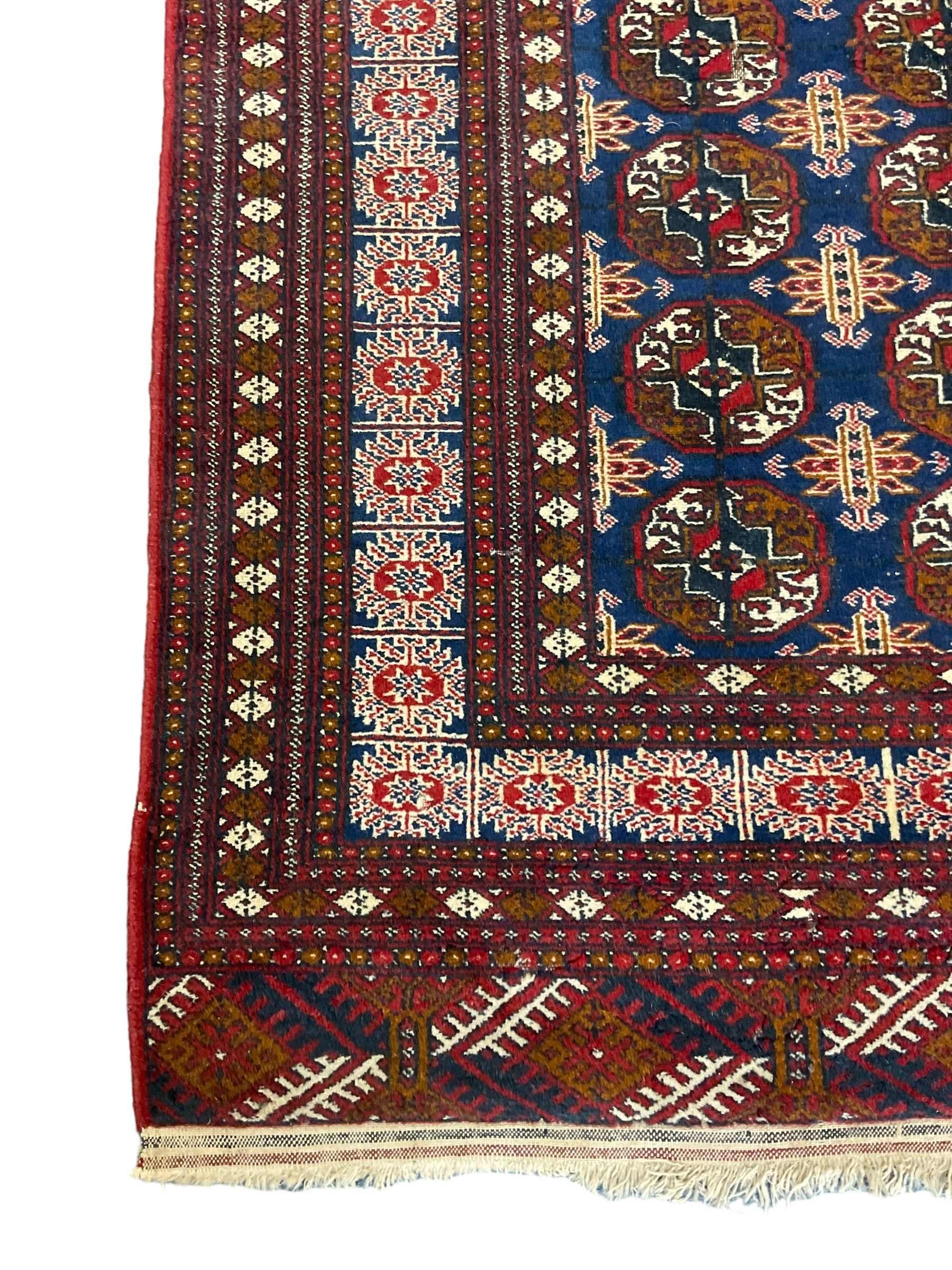 Persian indigo Bokhara rug, decorated with three rows of Gul motifs
