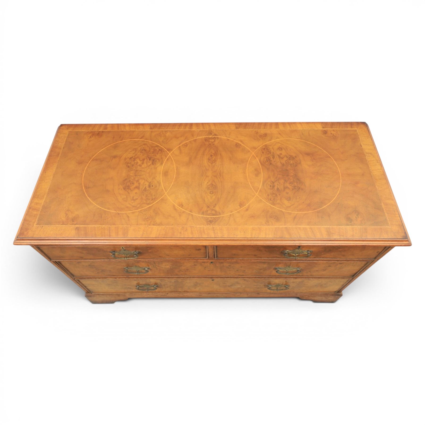 Traditional design walnut inlaid chest, with figured top with circular inlay and crossbanded top with moulded edge, figured drawers with cockbeaded edges and brass handles, raised on bracket feet