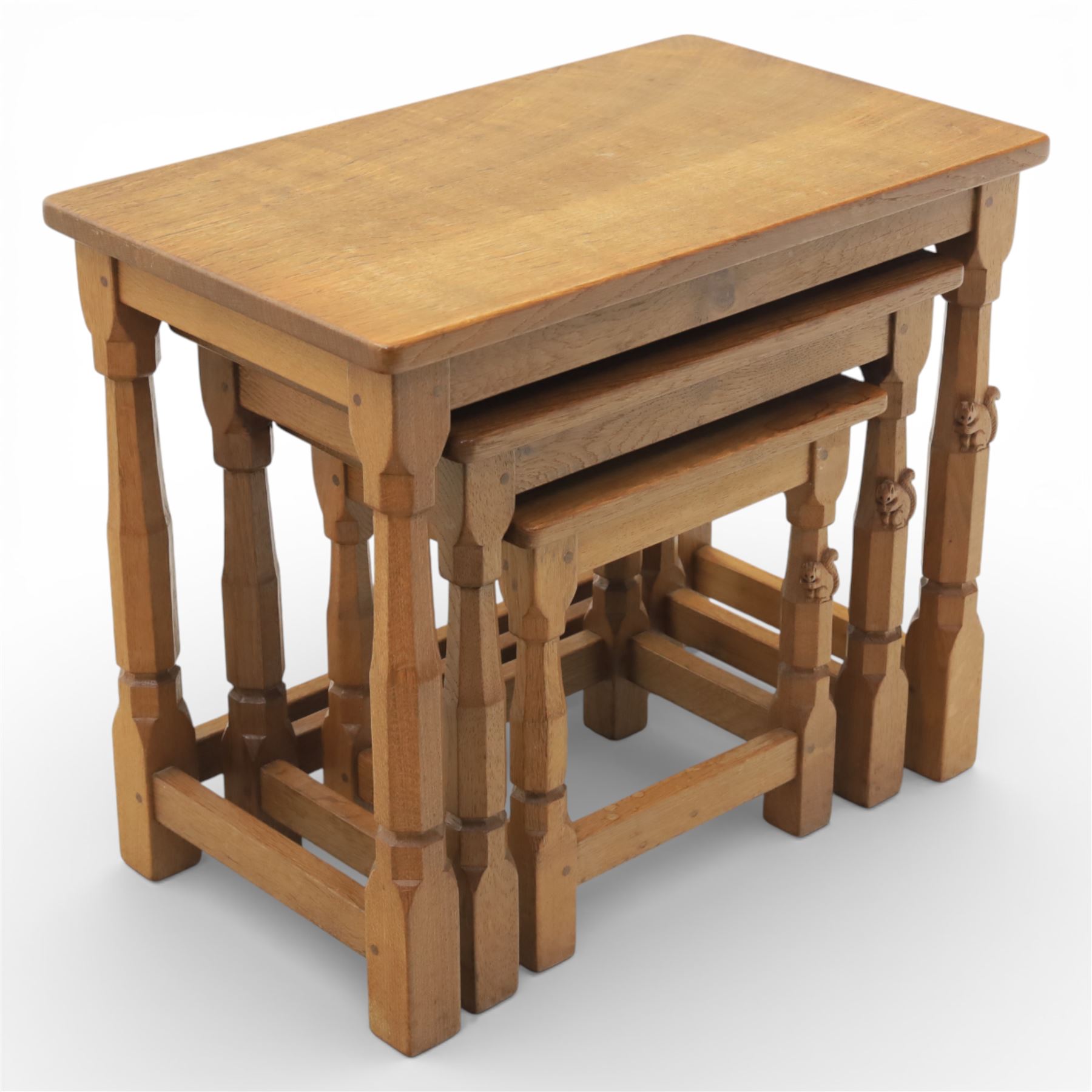 Squirrelman - nest of three tables, each with rectangular top upon octagonal turned supports with squirrel carving, by Wilfrid Hutchinson, Husthwaite