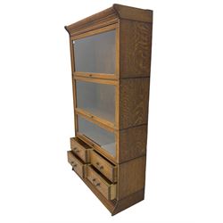 Early 20th century Globe Wernicke style oak library bookcase, three sections enclosed by hinged and sliding glazed doors, the lower section fitted with four small drawers
