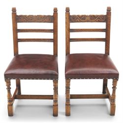 Craftsman made set of four solid oak dining chairs with leather seats, with carved cresting rail, on red leather seats with studded trim, raised on block and turn supports united by H-stretcher