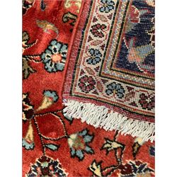 Persian Ardakan crimson ground rug, the field with shaped floral design medallion surrounded by curled leafy branches, scrolling border with stylised plant motifs