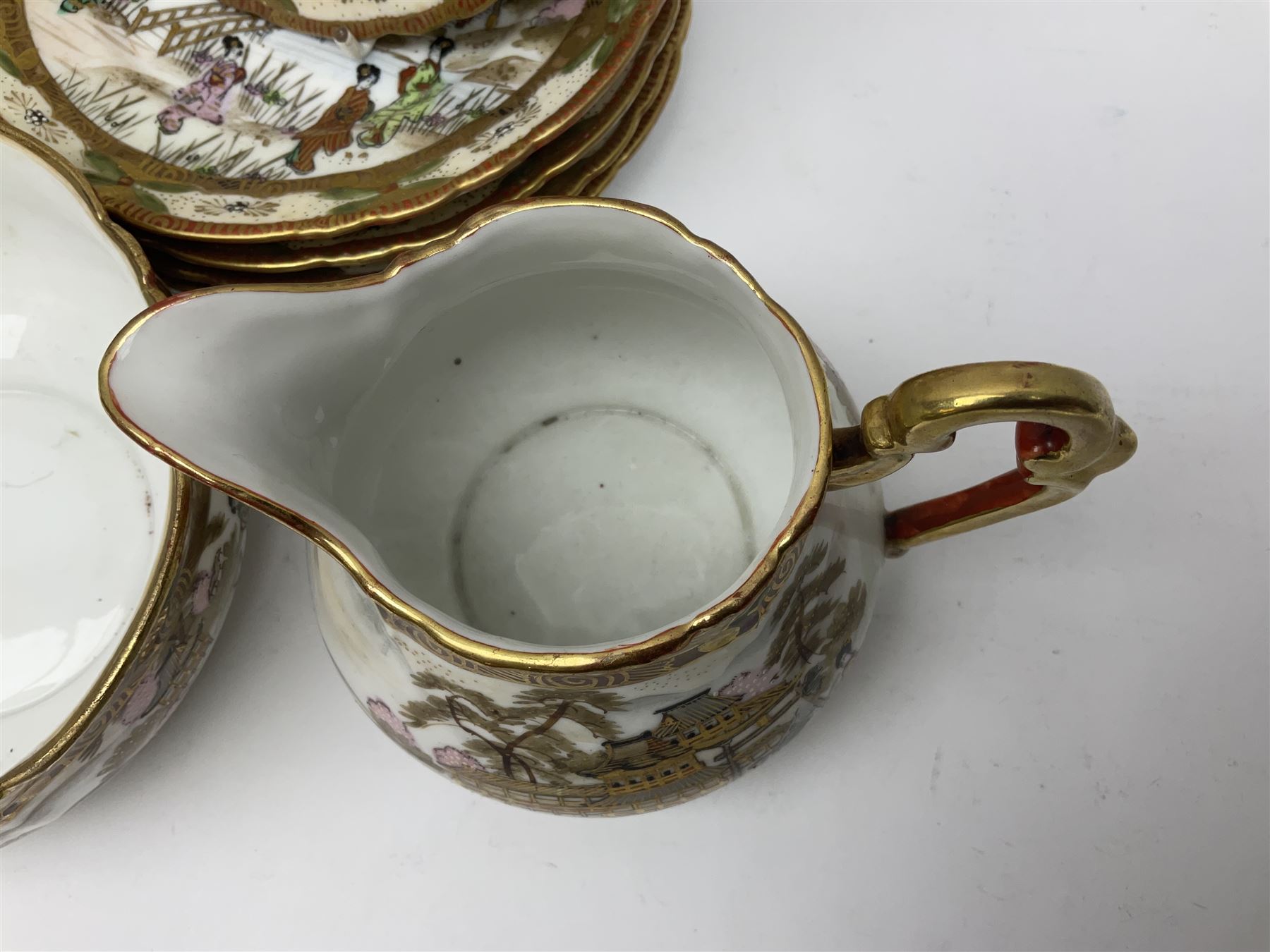 Noritake part tea service, printed and painted with figures in a landscape, comprising ten  tea cups and saucers, ten dessert plates, milk jug and sugar bowl