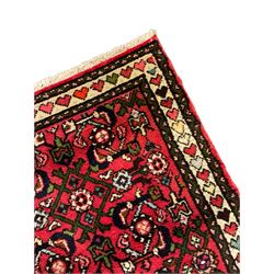 Persian red ground runner, decorated with large Herati motifs and shaped central medallion, the guarded border decorated with repeating heart motifs