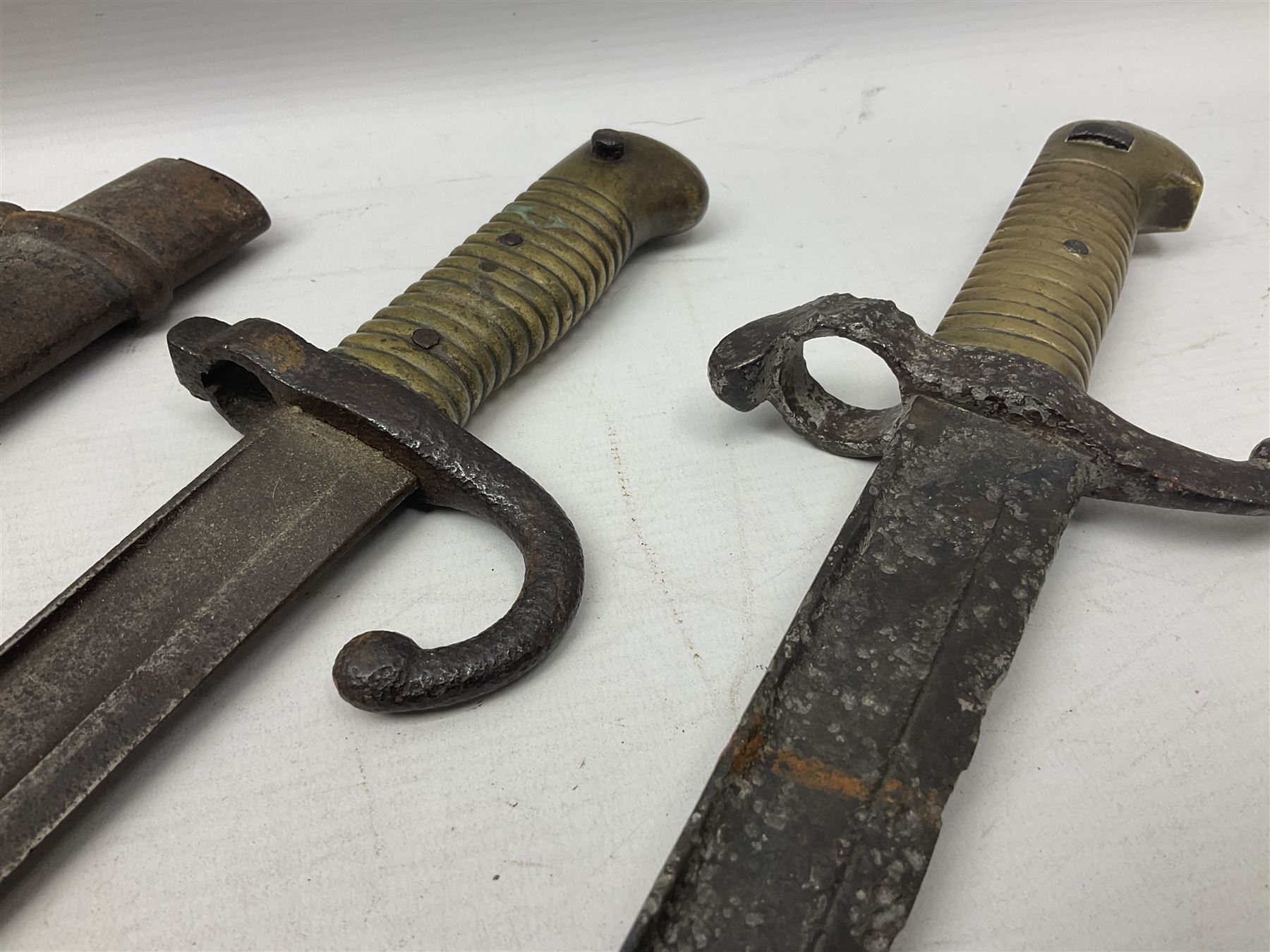 French Model 1874 Epee bayonet marked Oulle 1876 in associated scabbard; Model 1866 sabre bayonet in cut-down sword scabbard; and Model 1842/59 sabre bayonet in relic condition (3)