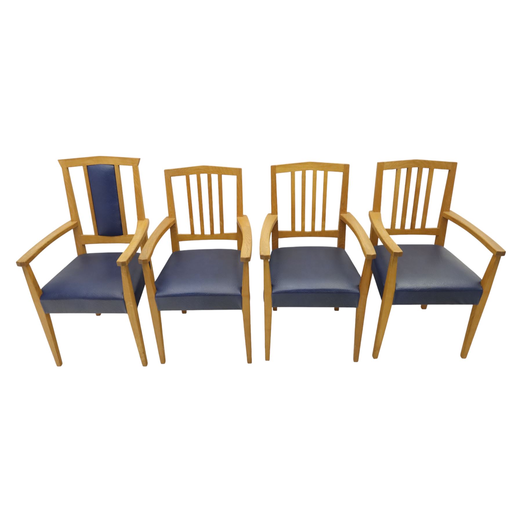 Modern twelve oak dining chairs including one 'Chairmans' chair, solid oak construction, slatted back and arm rests, blue leatherette padded seat, on tapered square supports 