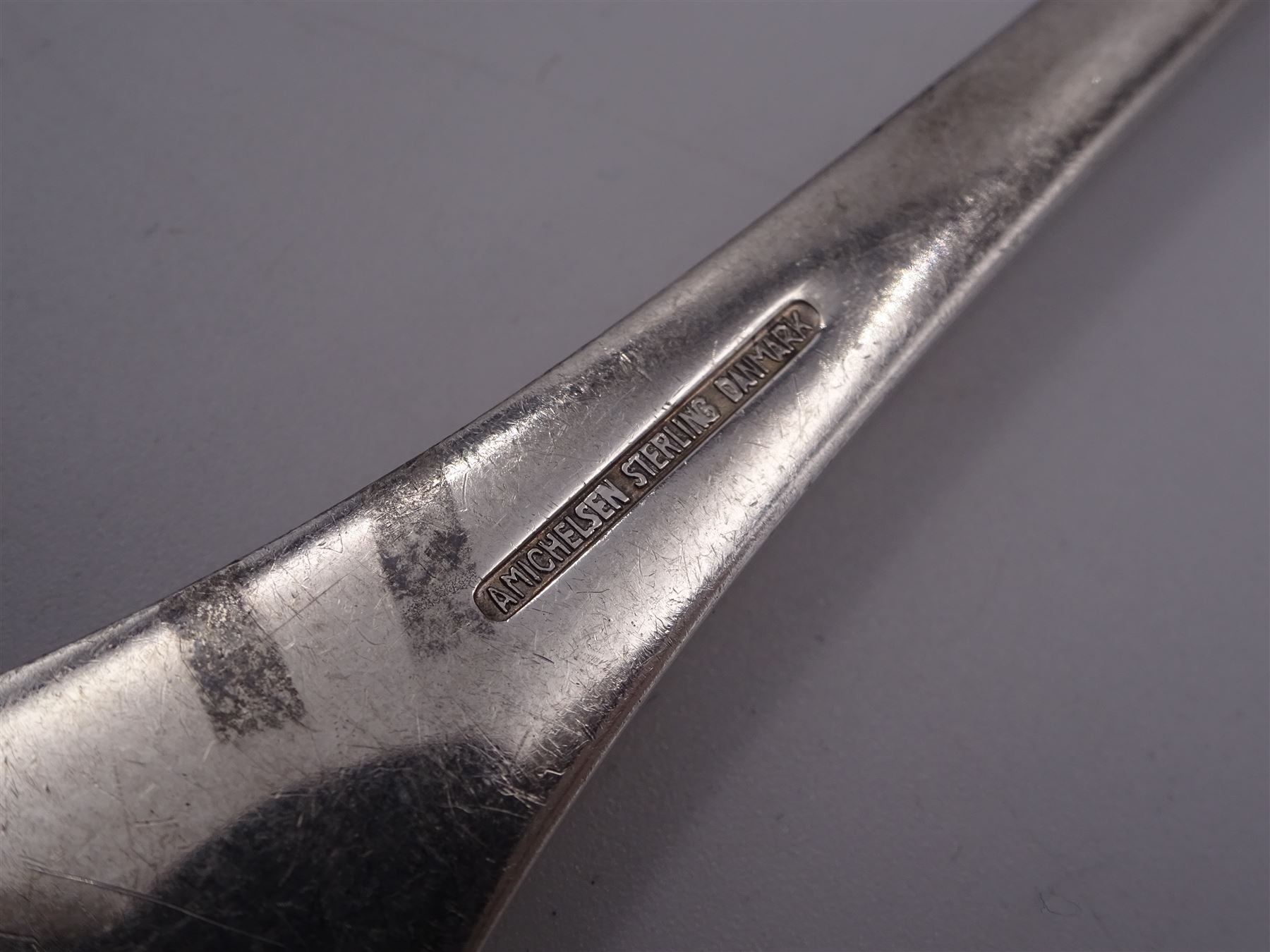 Two Danish silver-gilt year spoons by Georg Jensen, the first example decorated with enamel blue cornflower motif, dated 1972, in original pouch, the second example decorated with enamel pink briar rose motif, dated 1976, in original box, each impressed on underside RA AB, Sterling Denmark, and marked for Georg Jensen, together with two further examples by A.Michelson, the first with orange enamel fan design, dated 1965, impressed on underside A.Michelsen Sterling Danmark, TH, the second with enamel family scene, dated 1973, impressed on underside 925 S A.Michelsen Sterling Danmark, B Spang Olsen, approximate gross weight 6.11ozt (190.4 grams)