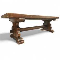 Early 20th century French oak refectory table, the thick rectangular top with cleated ends above shaped lyre-form trestle supports, united by a central stretcher, on broad scrolled feet, displaying well-figured quarter sawn grain across the top
