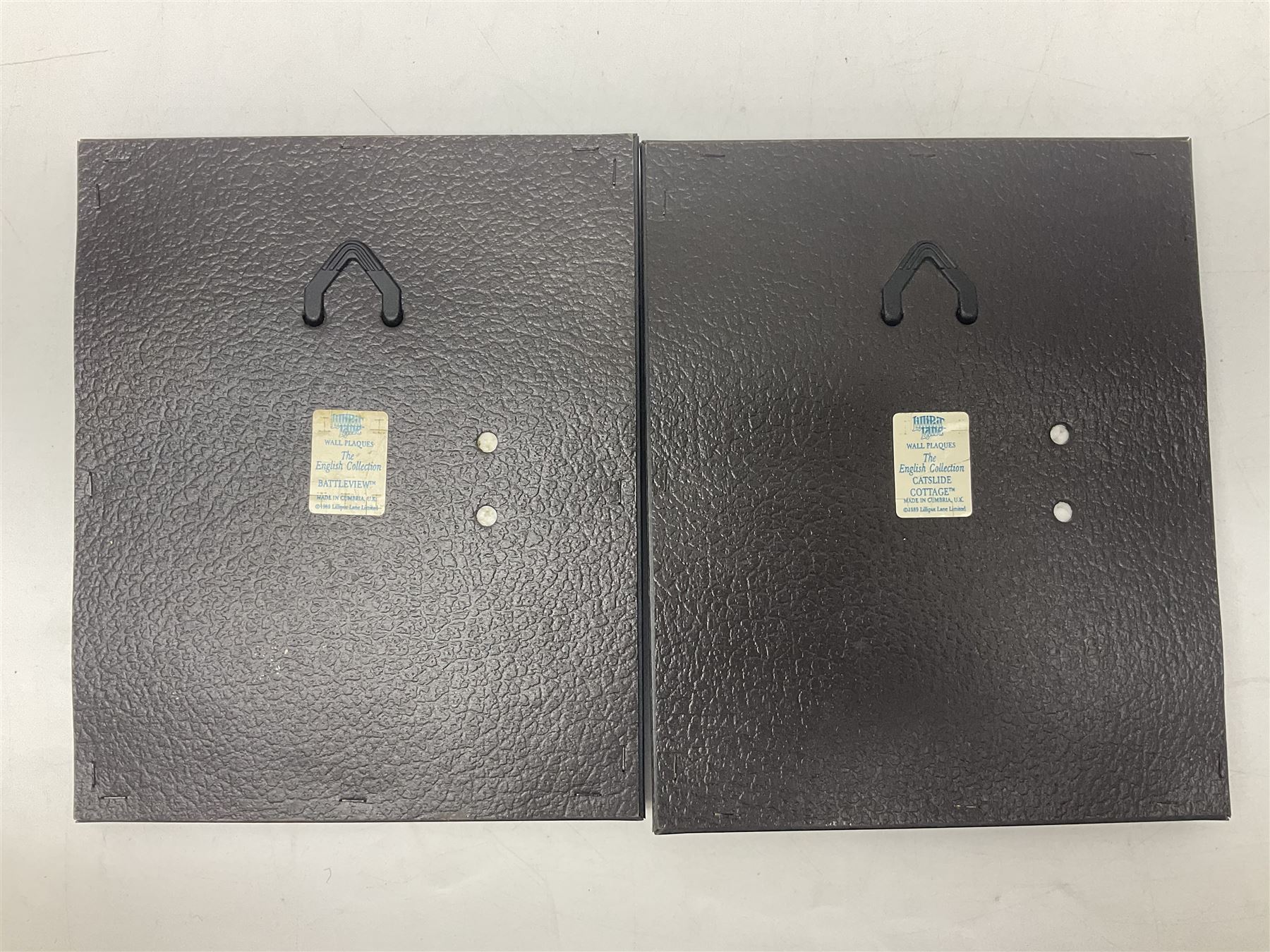 Nine Lilliput Lane framed wall plaques, including Fell View, Battleview, Catslide Cottage, Ashdown Hall and Shannon's Bank, together with three smaller circular framed Lilliput Lane plaques