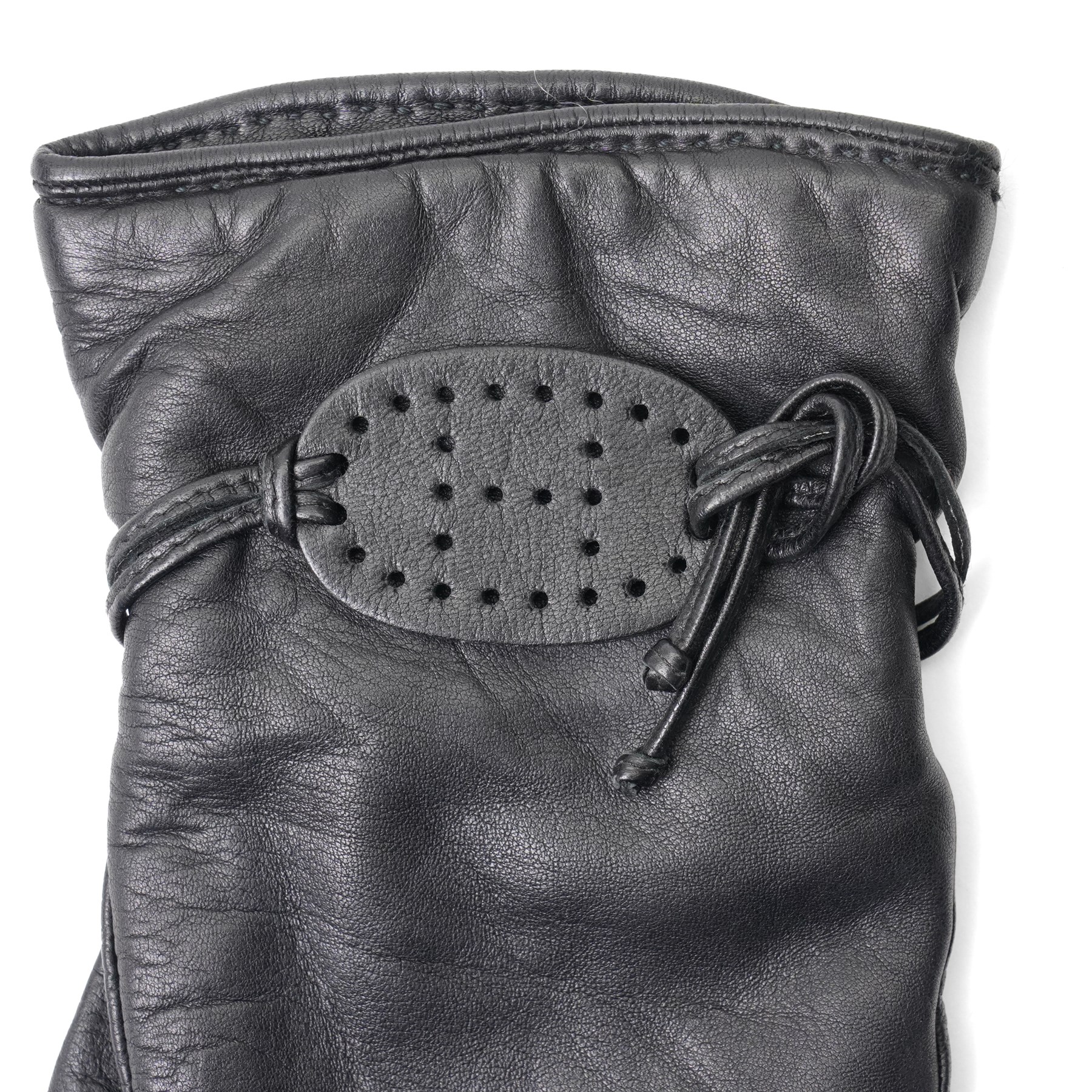 Hermès - pair of black leather gloves, lined in 100% cashmere, with pierced oval leather strap detail to cuffs, size 8
