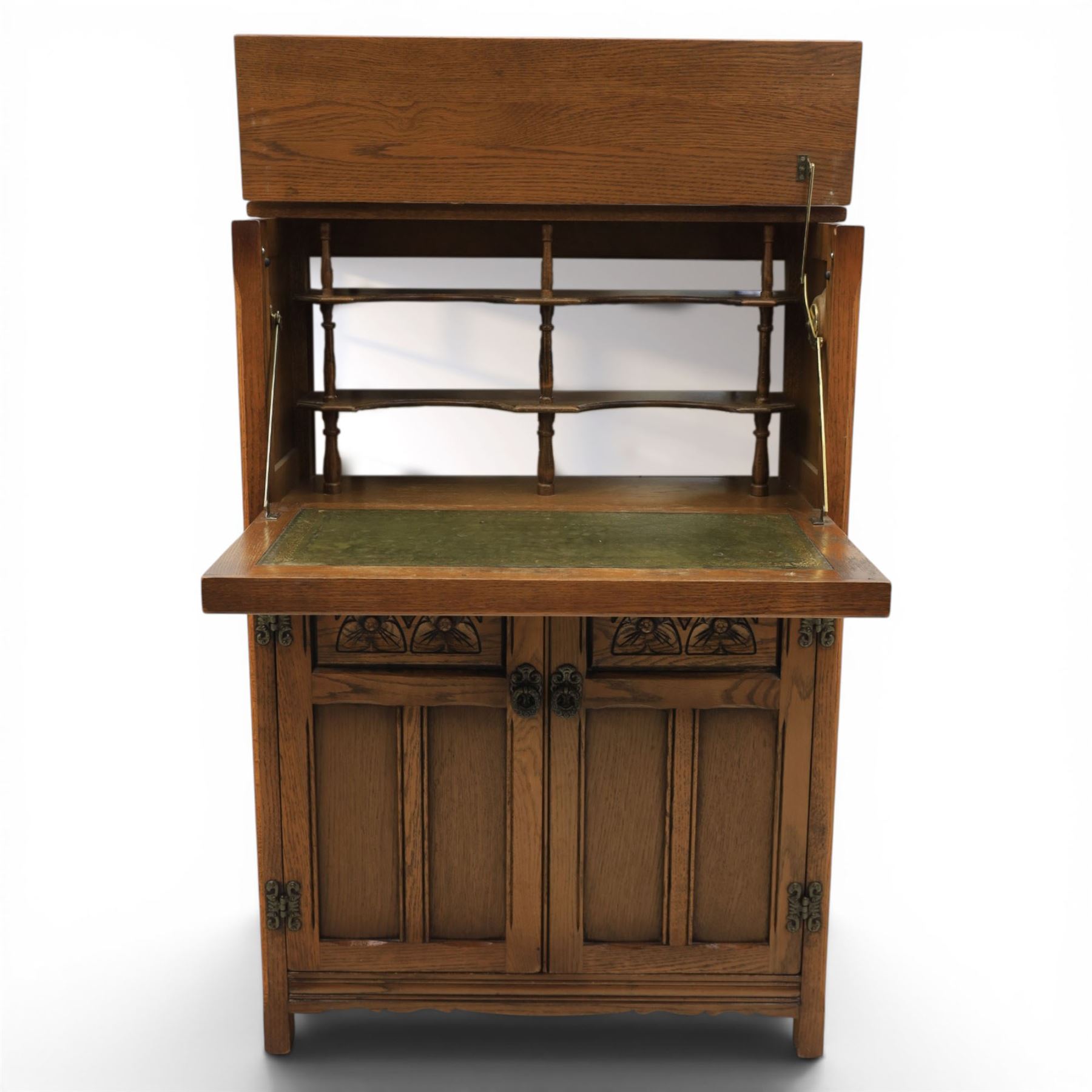 Old Charm - carved oak bar with three bar stools and associated Old Charm drinks cabinet, carved top with channels for glassware beneath, bar surface above glazed panels, shelves for glassware to the back, associated Old Charm drinks cabinet with fall front linenfold carving, above twin doors with shelved interior