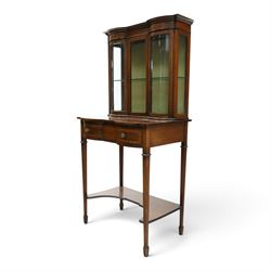 Edwardian inlaid mahogany serpentine-front side cabinet, raised back with central glazed door flanked by bow-front glass panels, the base fitted with banded and shaped frieze drawer, on square tapering supports united by concave under-tier