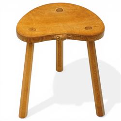 Mouseman - oak three-legged stool, dished kidney-shaped seat, raised on three octagonal splayed supports, with carved mouse signature, by the workshop of Robert Thompson of Kilburn