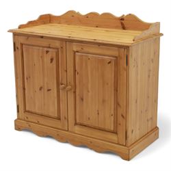 Contemporary pine cupboard, with raised shaped gallery over plain top, panelled double doors below with turned knob handles, shaped apron and plinth base
