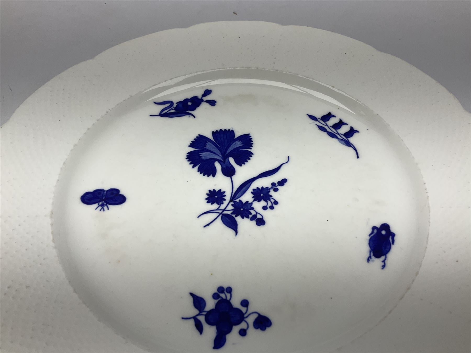 Three 19th century plates, comprising two circular examples and one oblong, each with osier moulded sides, the centres decorated in underglaze blue with Gillyflower type pattern, circular examples D25cm oblong example W27cm