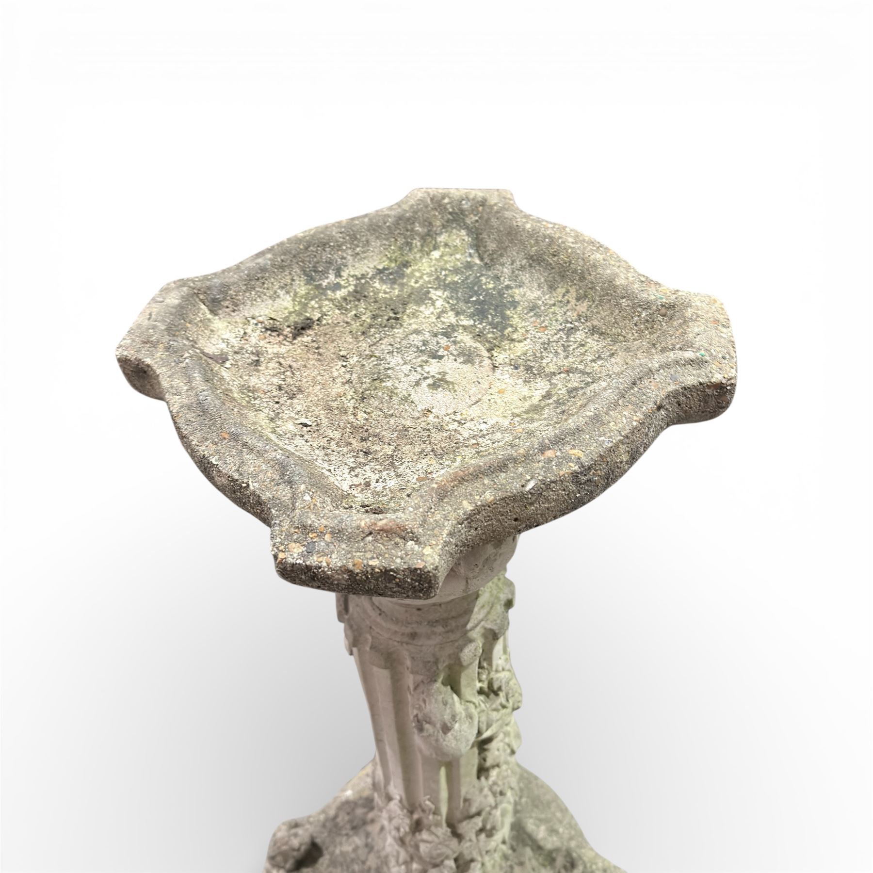 Cast stone bird bath on pedestal with cast iron water pump