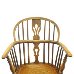 19th century low back elm Windsor armchair, hooped back with pierced central splat and radiating spindles, shaped arm bow over saddle seat, on turned supports united by crinoline stretcher