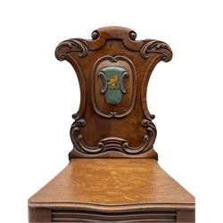 Victorian mahogany hall chair, shield panel back carved with c-scrolls and foliage, with crest cartouche mount depicting rampant lion on blue and yellow stripe, serpentine moulded seat, turned and carved front supports