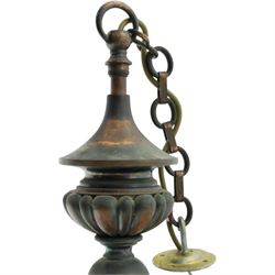 Art Nouveau copper three branch chandelier, turned central column with foiliate collar, issuing three scrolling strapwork arms, fitted with cut glass pendant shades, suspended from a chain