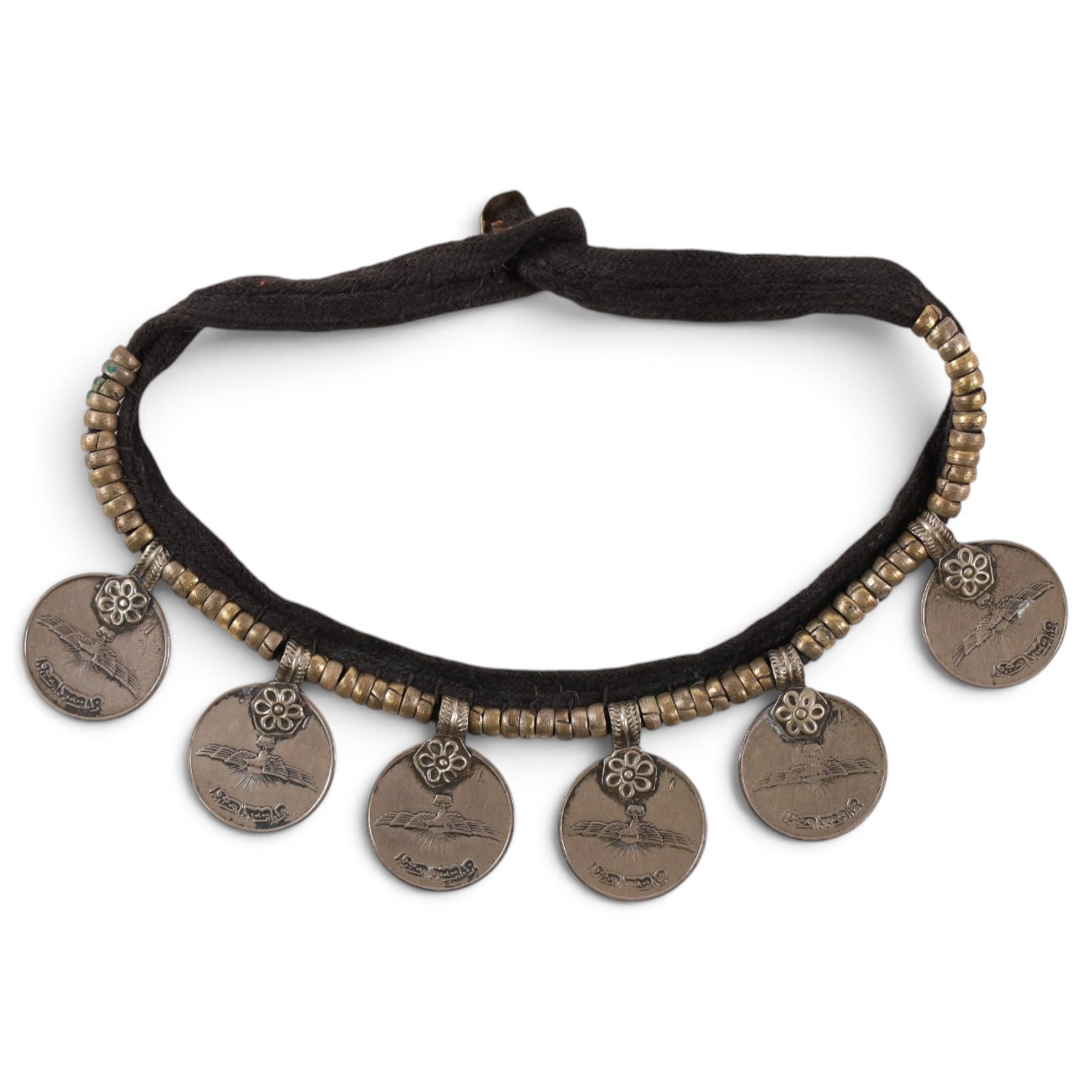 Collection of Middle Eastern jewellery, including silver necklace with a crescent  shaped pendent with beadwork and barrel tasselled ends, nickel silver wedding necklace with filigree decoration, coin bracelet, two bridal wedding caps and two others 