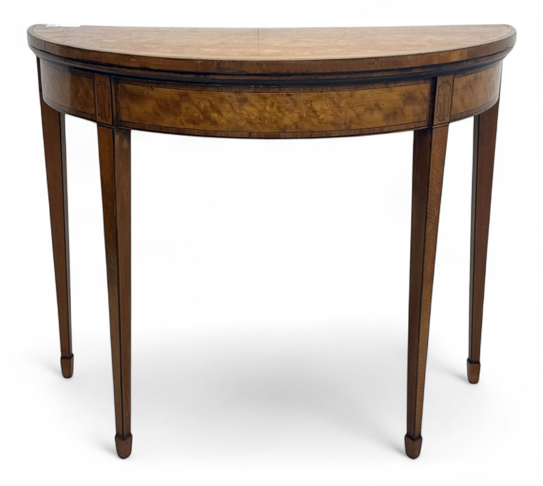 Edwardian satinwood inlaid demi-lune card table, hinged fold over green baize lined interior, raised on square tapered supports with spade feet  