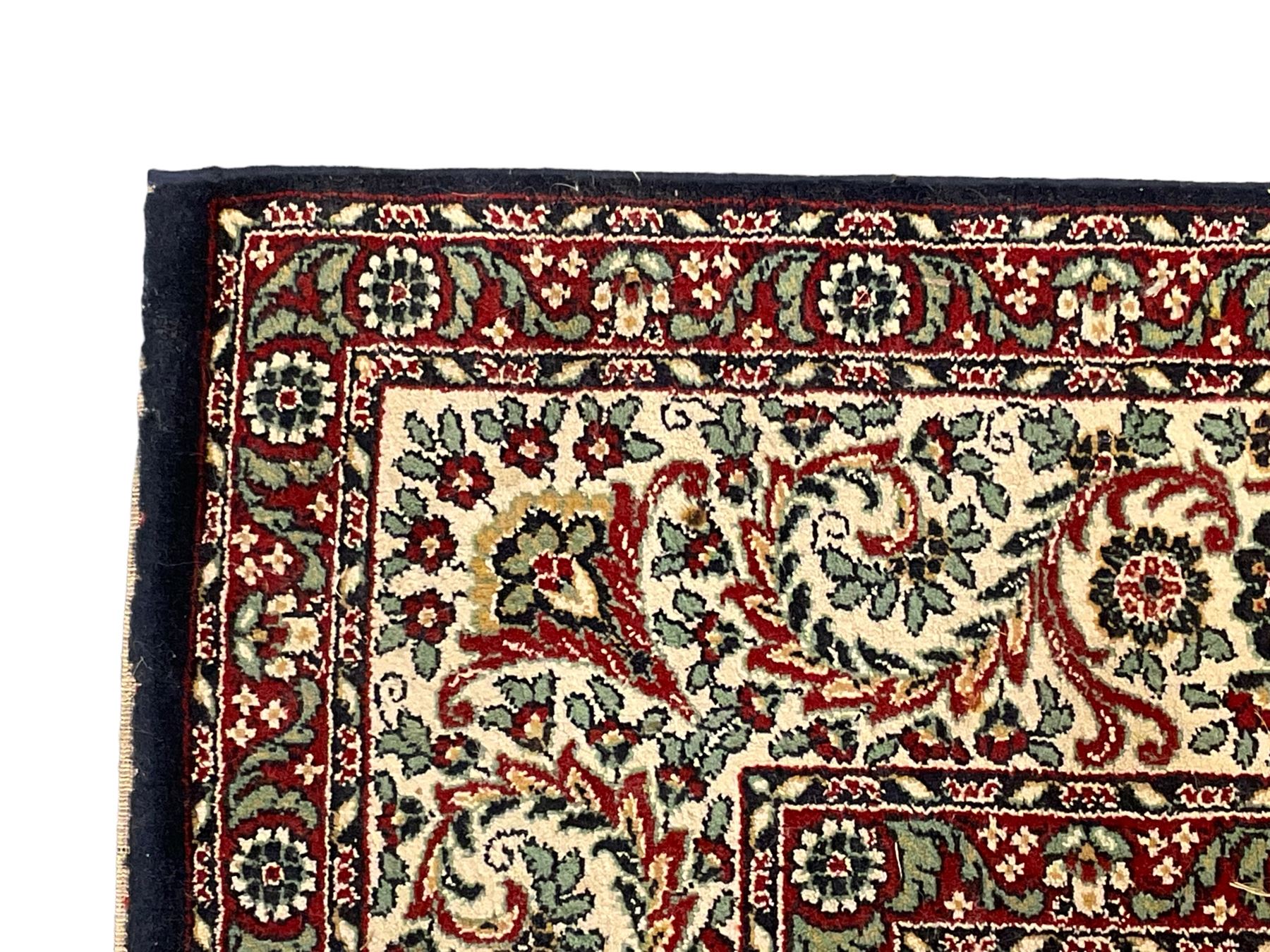 Persian design crimson ground carpet, the central rosette medallion surrounded by scrolling leaves and flower heads, the spandrels decorated with floral design and scrolling foliage, repeating border within guard stripes