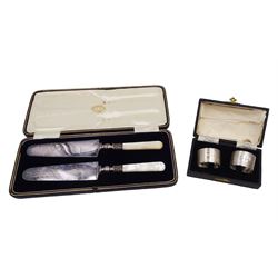 Pair of mid 20th century silver napkin rings, both engraved with initials, hallmarked, together with a pair of cake slices, with hallmarked silver ferrules and mother of pearl handles, both within fitted cases
