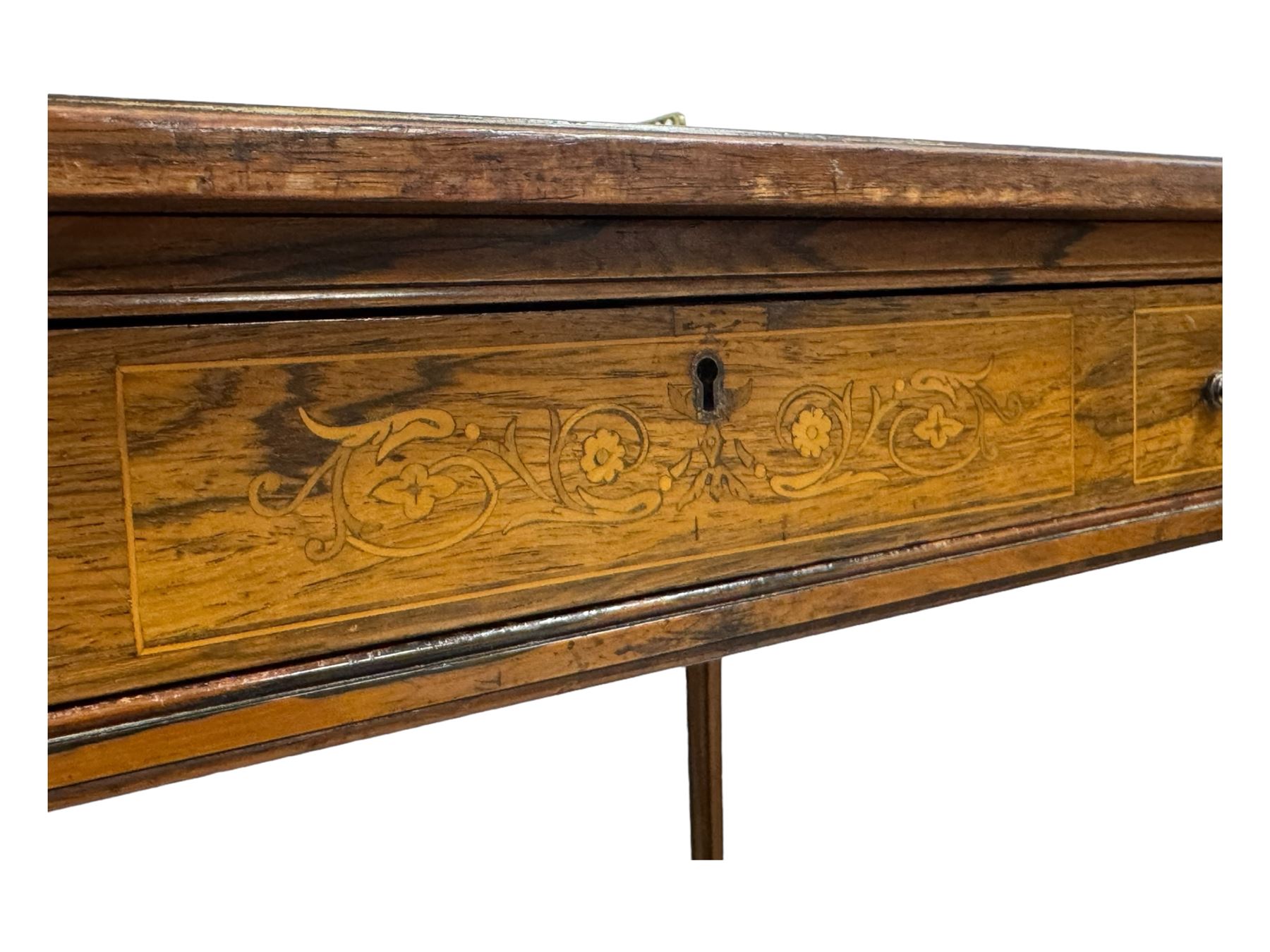 Late Victorian walnut writing table, rectangular leather-inset top surmounted by a brass gallery, fitted with a single frieze drawer, raised on turned tapering supports with lower undertier and ceramic castors