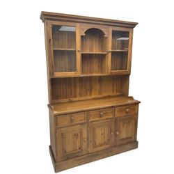 Polished traditional pine dresser, the raised back fitted with two display cabinets, the base fitted with three drawers and three cupboards