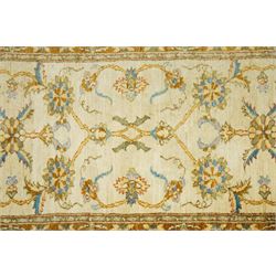 Modern Pakistani Oushak style hand-knotted runner,  ivory field with an all-over scrolling floral vine design incorporating stylized palmettes and rosettes in soft tones of pale blue, sage green and muted gold, enclosed by conforming border, cotton fringe ends 