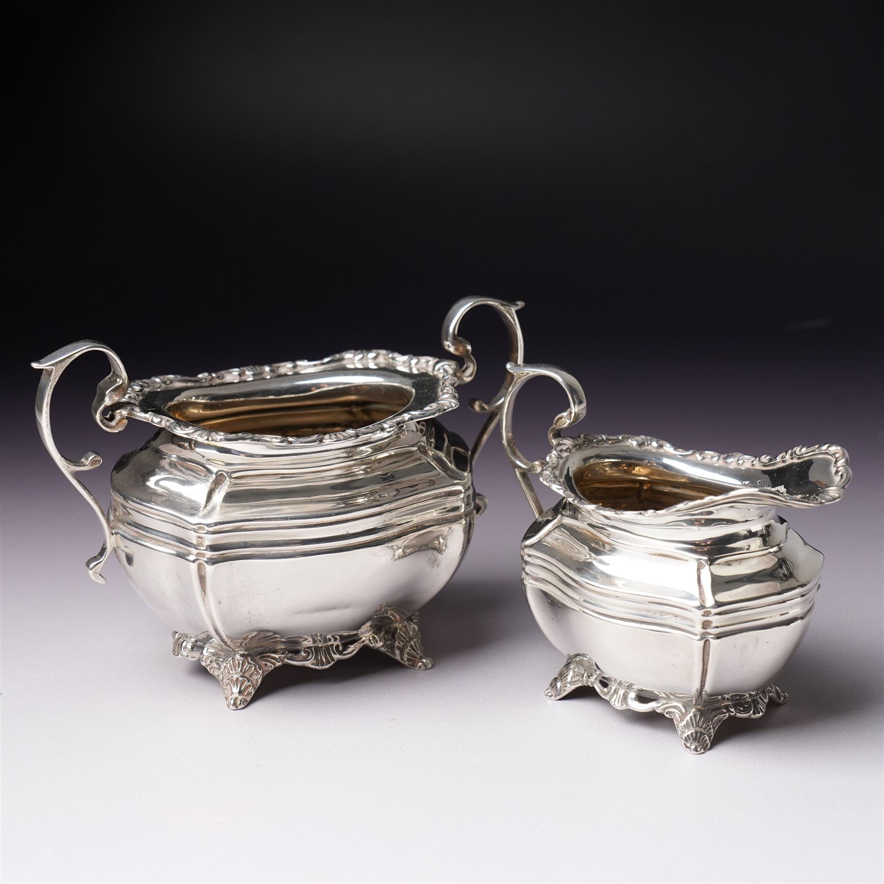 Edwardian silver three piece bachelors tea set of panel sided rectangular form with shell and scroll borders on shell moulded feet London 1903- 1905 Maker Josiah Williams & Co