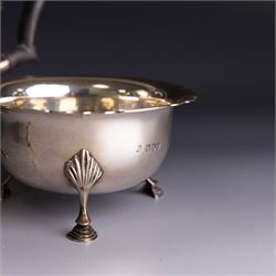 Early 20th century silver three piece bachelor's tea service, comprising teapot, open sucrier and milk jug, all of circular waisted form with shaped rims and upon three stepped feet, the teapot with ebonised wooden handle and finial, hallmarked Wakely & Wheeler, London 1914, teapot height H15cm