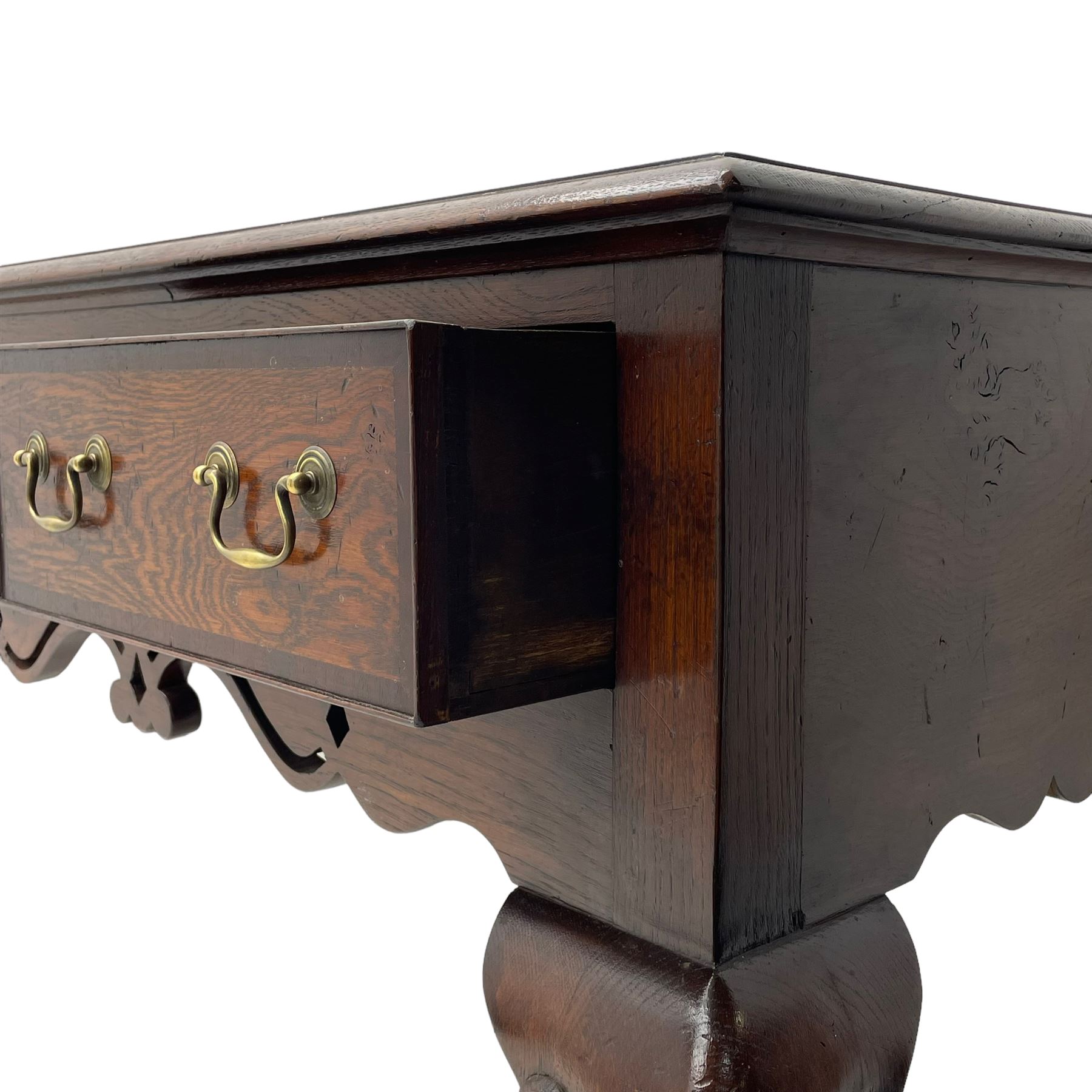 Georgian design oak and mahogany dresser base, the rectangular moulded top with mahogany band, three cocked-beaded and banded drawers over shaped a pierced apron, circular brass handle plates and swan neck handles, on C-scroll carved cabriole supports 