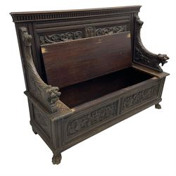 19th century oak hall bench, dentil cresting rail over moulded frame with panelled back carved with fire-breathing mythical beasts and central acanthus leaf motif, scroll carved down-sweeping arms carved with grotesque masks with scrolled foliage and shells, hinged box seat carved with scrolling foliage over panelled front with further carved foliage decoration, on paw carved front feet 