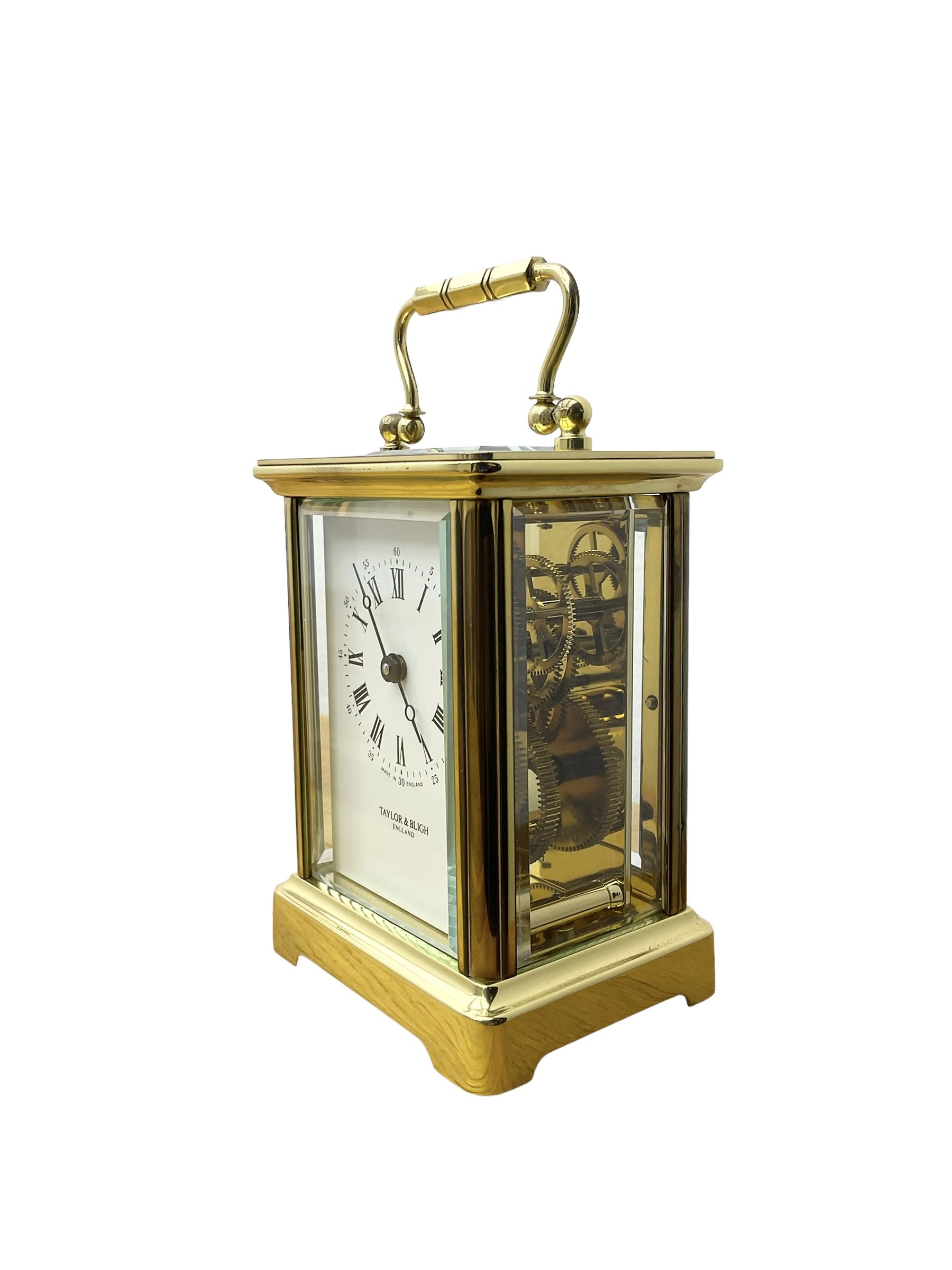 Taylor & Bligh - English 8-day carriage clock in a corniche-style case, white dial with roman numerals and steel moon hands, 11 jewel movement with a lever platform escapement. With key.