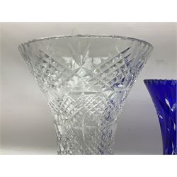 Heavy bohemian blue overlaid cut glass vase of waisted form with hobstar decoration and star cut base, together with a larger clear vase of similar form with flared rim, tallest H35cm