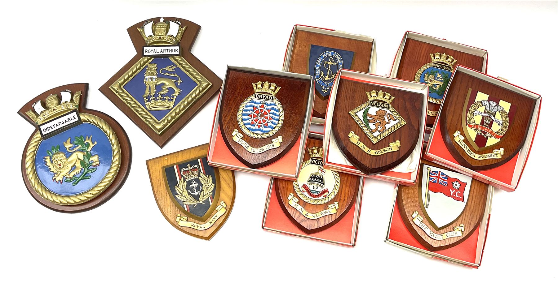 Various Navy wooden heraldic shields each with hand painted raised shield, including HMS Indefatigable, HMS Nelson,  HMS Victory etc, ten in total.  