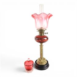 Victorian oil lamp, with etched shade with fluted rim, above a cranberry reservoir, on twi...