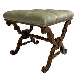Victorian walnut dressing stool, square seat upholstered in buttoned laurel green fabric, raised on twin shaped X-frame end supports with carved S-scroll decoration, united by a turned stretcher 