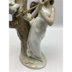 Lladro figure, Musical Muse, modelled as a woman playing a flute under a tree, sculpted by Antonio Ramos, with original box, no 5651, year issued 1990, year retired 1996, H34cm