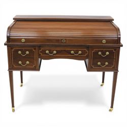George III style inlaid mahogany tambour desk, the roll top enclosing fitted interior with small drawers and compartments above inset leather writing surface, over three frieze drawers, raised on square tapering supports with brass caps and castors
