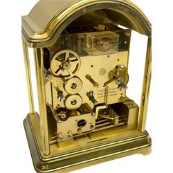 A 20th century brass cased Kieninger (German) chiming mantle clock with a break arch top and three glazed panels, polished sheet brass dial with applied  brass fretwork and a silvered chapter ring, Roman numerals, minute track, steel serpentine hands and seconds dial, three-train spring driven 8-day movement with Westminster, St Michael and Whittington chimes on 8 gong rods, 9 jewel lever platform escapement.  With key. 