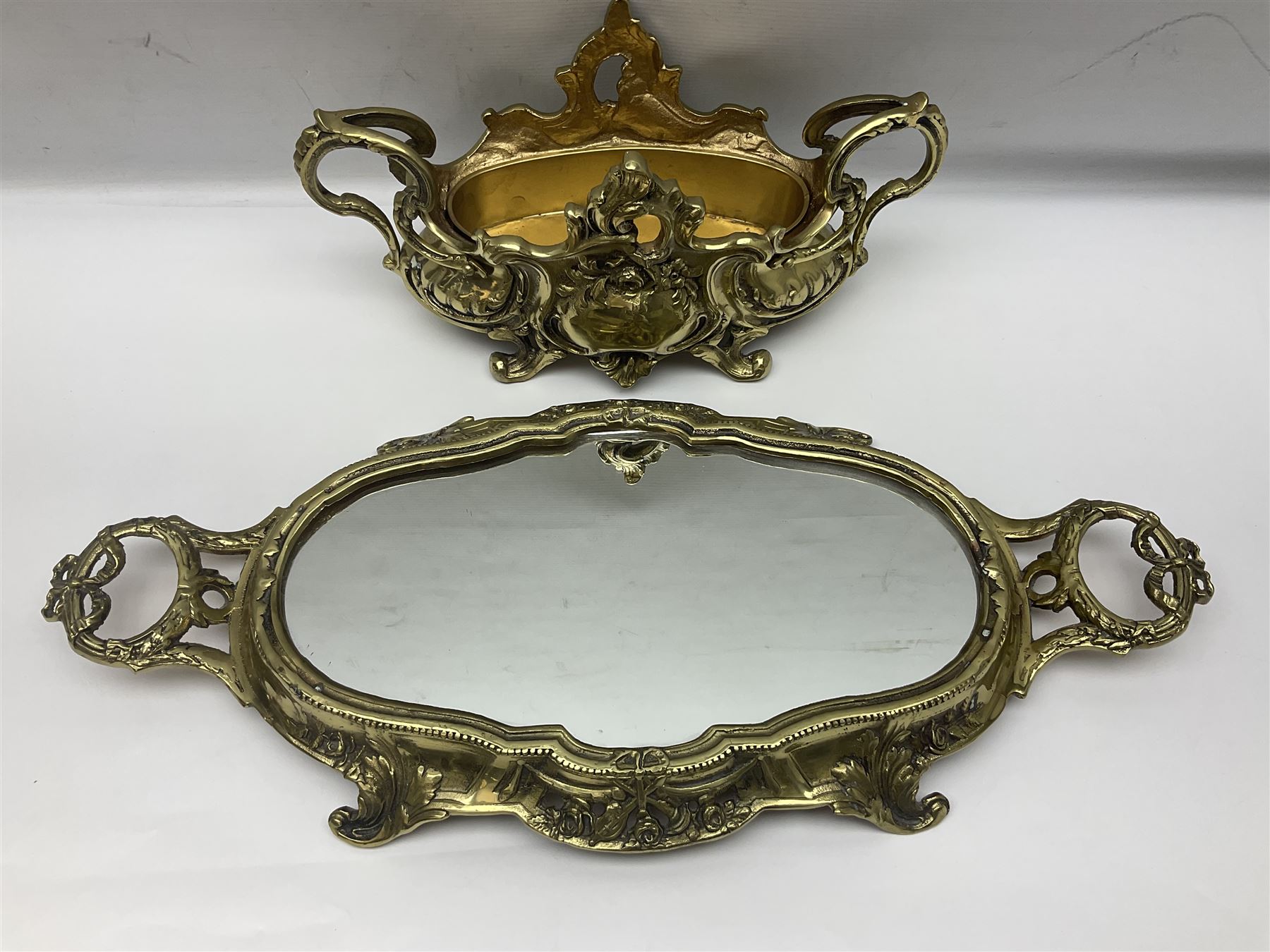 Ornate brass centrepiece, with twin handled vase upon a mirrored base, with floral and scrolling decoration, H23cm 