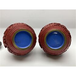 Pair of Chinese cinnabar lacquer vases, each of bulbous baluster form, carved with peonies and foo dogs amongst scrolls, with blue enamel interior and upon wooden bases, H20cm