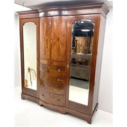Edwardian inlaid mahogany triple wardrobe, bow front centre with two cupboards above four graduating drawers flanked by two bevel edged mirror doors, shaped platform base 