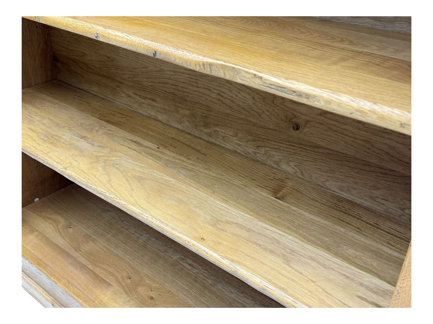 Contemporary French provincial design oak open bookcase, with projecting moulded cornice above a boarded back, fitted with four adjustable shelves, on bracketed plinth base