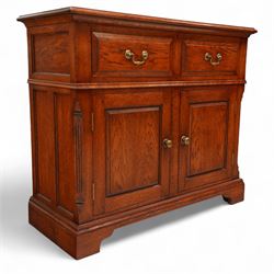 20th century country oak side cabinet, rectangular top over two short drawers and twin panelled cupboard doors, flanked by reeded uprights, on plinth base