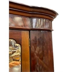 Late 19th century mahogany double wardrobe, projecting cornice over figured frieze, curved uprights enclosing two doors with bevelled mirrors, drawer to base, on splayed bracket feet