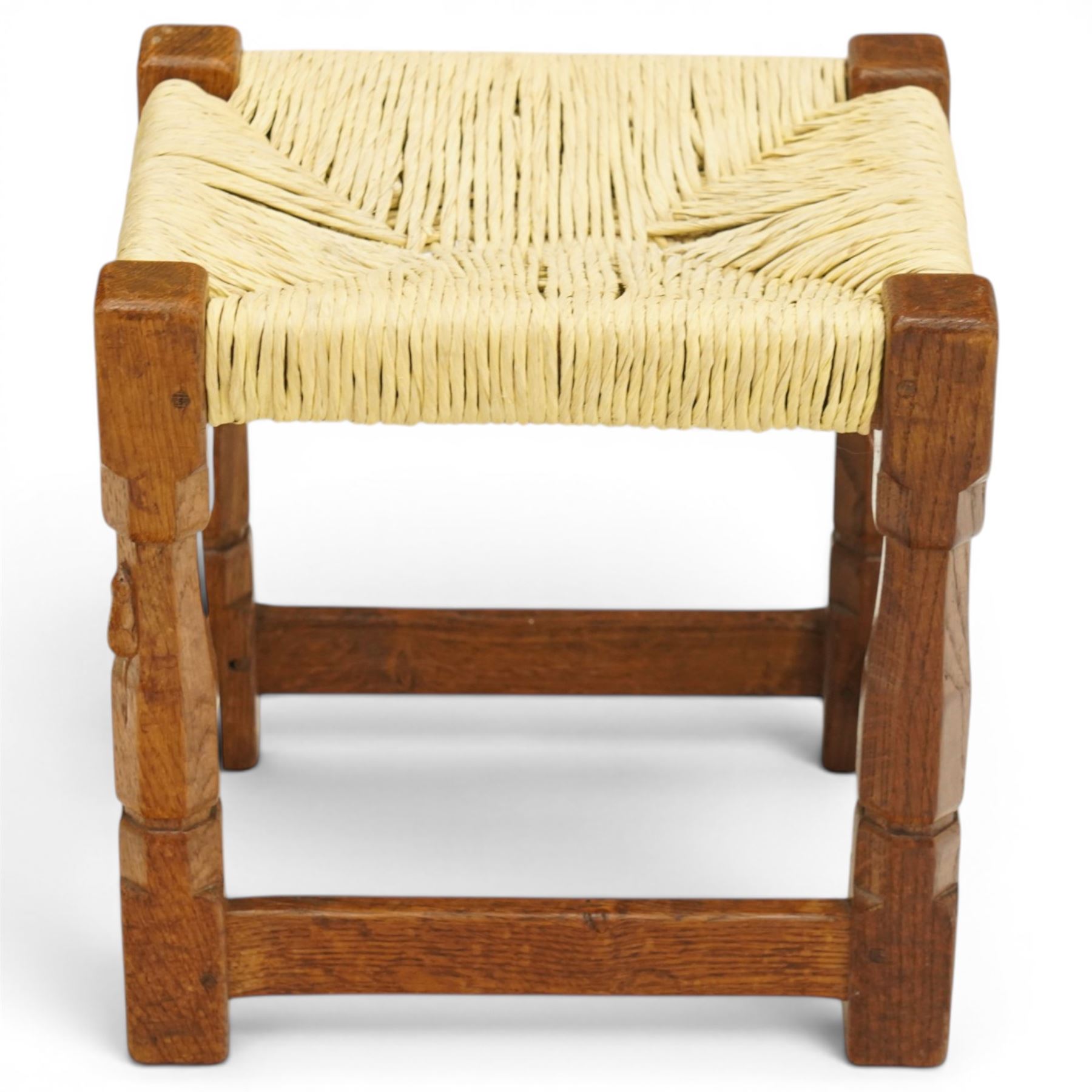 Mouseman - mid-20th century oak stool, the rectangular rush seat raised on turned octagonal supports united by box stretcher, with carved mouse signature, by the workshop of Robert Thompson of Kilburn